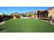 Spacious backyard with lush green lawn, pool, covered patio, and desert landscaping at 38820 N 19Th Way, Phoenix, AZ 85086