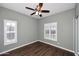 Empty bedroom with ceiling fan, wood-look tile flooring, and two windows at 38820 N 19Th Way, Phoenix, AZ 85086