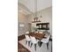 Dining room with a modern wooden table, white upholstered chairs, and a unique hanging light fixture at 38820 N 19Th Way, Phoenix, AZ 85086