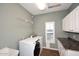 Laundry room with white cabinets, granite countertops, and tile flooring at 38820 N 19Th Way, Phoenix, AZ 85086