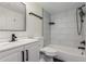 Modern bathroom with white vanity, bathtub, and gray tile at 3411 N 12Th Pl # 9, Phoenix, AZ 85014