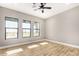 Bright bedroom with ceiling fan, wood-look floors, and multiple windows at 569 S May Pl, Casa Grande, AZ 85194