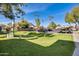 Community parking lot with covered spaces and grassy areas at 222 W Brown Rd # 117, Mesa, AZ 85201