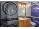 Bathroom boasts blue tile, wood vanity, and stackable washer/dryer at 3498 N Morningside Rd, Apache Junction, AZ 85119