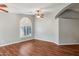 Living room with hardwood floors, ceiling fan, and arched windows at 4175 S Marisol Ln, Gilbert, AZ 85297