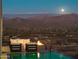 Luxury pool and patio area with breathtaking mountain views at night at 4880 E Lone Mountain N Rd, Cave Creek, AZ 85331