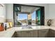 Modern kitchen features a large window showcasing scenic mountain views and outdoor grilling area at 4880 E Lone Mountain N Rd, Cave Creek, AZ 85331