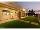 Artificial turf backyard with a stone patio and lights at 2346 E Sanoque Ct, Gilbert, AZ 85298