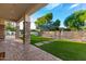 Landscaped backyard with a covered patio and pool access at 2346 E Sanoque Ct, Gilbert, AZ 85298