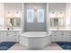 Elegant bathroom with a soaking tub, double vanity, and grey tile at 2346 E Sanoque Ct, Gilbert, AZ 85298