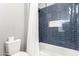 Bathroom with blue tile shower/tub surround and white toilet at 2346 E Sanoque Ct, Gilbert, AZ 85298