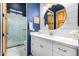 Bathroom with white vanity, round mirror, and navy blue walls at 2346 E Sanoque Ct, Gilbert, AZ 85298