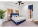 Bedroom with blue velvet headboard bed, wood shutters, and ceiling fan at 2346 E Sanoque Ct, Gilbert, AZ 85298