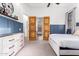 Bedroom with white dresser, double doors to bathroom, and blue wall paneling at 2346 E Sanoque Ct, Gilbert, AZ 85298