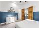 Bedroom with white dresser, double doors to bathroom, and blue wall paneling at 2346 E Sanoque Ct, Gilbert, AZ 85298