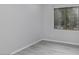 Simple bedroom with light gray walls, wood-look flooring, and a window with blinds at 3473 E Bruce Ave, Gilbert, AZ 85234