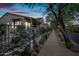 Evening view of charming house with stone facade and wrought iron fence at 9238 E Desert Park Dr, Scottsdale, AZ 85255