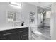 Modern bathroom with dark vanity, tiled shower, and white toilet at 19039 N 90Th Ln, Peoria, AZ 85382