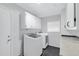 Bright laundry room with washer, dryer, and ample cabinet space at 19039 N 90Th Ln, Peoria, AZ 85382