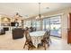 Bright dining room with a table for six, view of the backyard, and access to the living room at 27046 W Yukon Dr, Buckeye, AZ 85396
