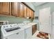Laundry room with washer, dryer, and ample cabinet space at 27046 W Yukon Dr, Buckeye, AZ 85396