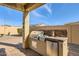 Outdoor kitchen with grill, sink, and mini-refrigerator at 27046 W Yukon Dr, Buckeye, AZ 85396
