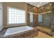 Bathroom with soaking tub, glass enclosed shower, and a block window at 1044 W Indian Hills Pl, Phoenix, AZ 85023