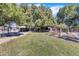Large backyard with grassy area, mature trees, and a trampoline at 14462 W Avalon Dr, Goodyear, AZ 85395