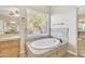 Relaxing bathroom with soaking tub and wood vanity at 14462 W Avalon Dr, Goodyear, AZ 85395