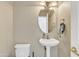 Small bathroom with pedestal sink and oval mirror at 14462 W Avalon Dr, Goodyear, AZ 85395