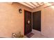 Condo's front door with a screen door and decorative welcome mat at 3030 S Alma School Rd # 12, Mesa, AZ 85210