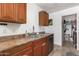 Functional kitchen with wood cabinets, double sink and access to laundry at 3030 S Alma School Rd # 12, Mesa, AZ 85210