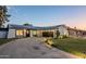 Modern home with a large driveway, solar panels, and well-manicured lawn at 3743 W Dailey St, Phoenix, AZ 85053