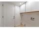 Bright laundry room with white cabinets and flooring at 3743 W Dailey St, Phoenix, AZ 85053