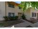 Tan stucco condo building with a walkway, landscaping, and trees at 8106 N 31St Dr, Phoenix, AZ 85051