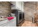 Laundry room with stone accent wall and modern washer/dryer at 2912 E Vaughn Ave, Gilbert, AZ 85234