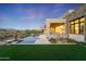 Luxury home with a stunning pool, expansive grassy backyard, and desert landscape at 9940 E Aleka Way, Scottsdale, AZ 85262
