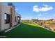 Expansive grassy backyard with artificial turf and modern home exterior at 9940 E Aleka Way, Scottsdale, AZ 85262