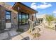 Stone and wood exterior with a covered entryway and desert landscaping at 9940 E Aleka Way, Scottsdale, AZ 85262