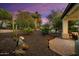 Desert landscaping with patio, lighting, and cacti at twilight at 12964 W Plum Rd, Peoria, AZ 85383