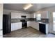 Modern kitchen with white cabinets, black appliances, and geometric backsplash at 151 E Patton Ave, Coolidge, AZ 85128