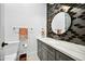Modern bathroom with dark tile, marble countertop, and a large mirror at 2335 E Plum St, Gilbert, AZ 85298