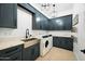 Laundry room with modern cabinetry, farmhouse sink, and washer/dryer at 2335 E Plum St, Gilbert, AZ 85298