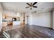 Open concept kitchen and living area with wood-look floors and ceiling fan at 41208 W Bravo Dr, Maricopa, AZ 85138