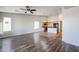 Open floor plan with kitchen island, wood-look flooring, and ceiling fan at 41208 W Bravo Dr, Maricopa, AZ 85138