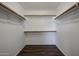 Large walk-in closet with double rods and wood-look floors at 41208 W Bravo Dr, Maricopa, AZ 85138