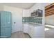 Modern kitchen with white cabinets, teal tile, and a microwave at 6312 N 13Th St, Phoenix, AZ 85014