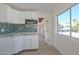 Modern galley kitchen with teal tile backsplash and white cabinets at 6312 N 13Th St, Phoenix, AZ 85014