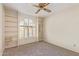 Bedroom with built-in shelving, ceiling fan and arched window at 9303 W Morrow Dr, Peoria, AZ 85382