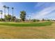 Green golf course with palm trees and residential homes in background at 9303 W Morrow Dr, Peoria, AZ 85382